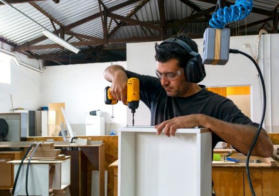 Carpintero montando un módulo de mueble a medida en el taller