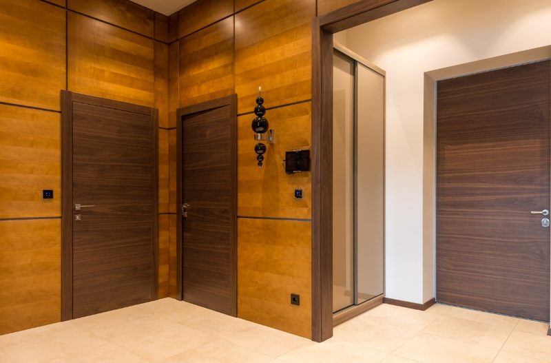 Recibidor con revestimiento de madera y puertas a juego
