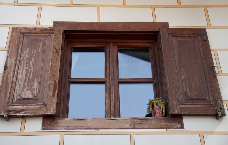 Ventana de madera con contraventanas en la fachada